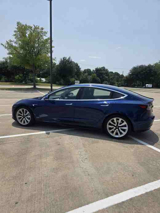 Blue Tesla Model 3 side profile in Dallas–Fort Worth