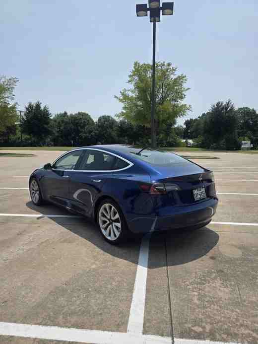 Blue Tesla Model 3 rear three-quarter view in Dallas–Fort Worth